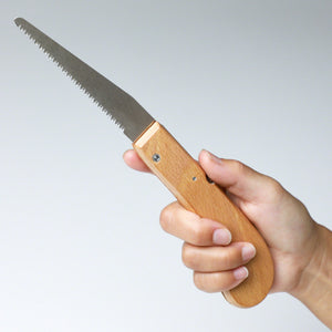 hand holding the folding saw with the blade out