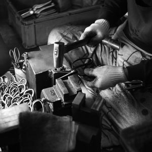 Artisan shaping the blades with a hammer