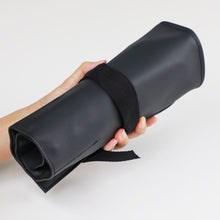 Load image into Gallery viewer, hand holding a rolled leather roll case 
