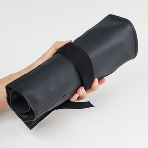 hand holding a rolled leather roll case 