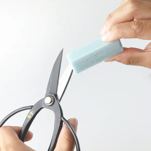 Hand using the fine Sap eraser on Scissors blades