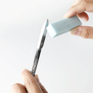 Hand cleaning the blade of a steel chisel with soft grade sap Eeraser