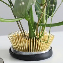 Load image into Gallery viewer, Close up on the radial kenzan with many stems planted on it
